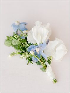 two white and blue flowers are on the table