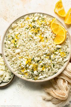 a bowl filled with rice, lemons and other ingredients next to sliced oranges