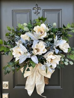 a bouquet of flowers is hanging on the front door with ribbon around it's bow