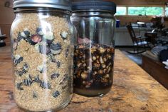 two jars filled with food sitting on top of a counter