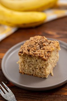 a close up of a piece of cake on a plate with bananas in the background