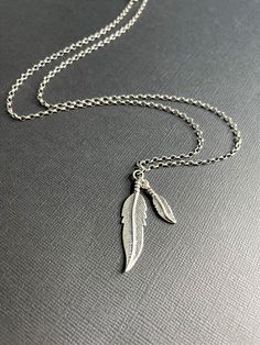 "Solid sterling silver necklace - Double Feather Necklace - this minimal men's or women's slightly oxidized silver necklace has a distressed look due to the darker gray shade of silver. This effect was intentionally created to accent the details and create a rustic vibe.  The necklace features a smooth rolo chain and a double feather pendant. ► Necklace / Chain Length - choose between 20-26\" + 1.65 in with pendant ► Pendant - 1.65 in ► Chain - 2.5 mm / Rolo ● 925 Sterling Silver ● Made to Order Mens Silver Chain Necklace, Oxidized Silver Necklace, Oxidised Silver Jewelry, Silver Necklace Chain, Feather Necklace, Mens Silver Necklace, Necklace Chain Lengths, Feather Pendant, Feather Necklaces