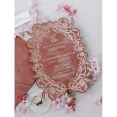 wedding stationery with pink flowers and gold trimmings on the back of an envelope