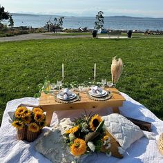 a picnic table set up with sunflowers and cheese