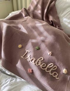 a blanket that has the word spelled in gold letters on it and flowers all over it