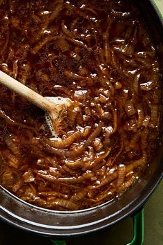 a large pot filled with lots of food and a wooden spoon in the middle of it