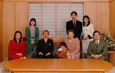 a group of people posing for a photo in front of a wooden table and wall