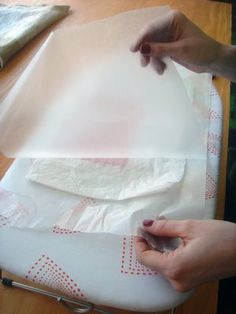 a person is cutting fabric with scissors on a table