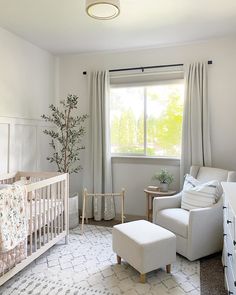 a baby's room with a crib, chair, and window in it