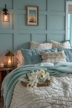 a bed in a bedroom with blue walls and white flowers on the bottom of it