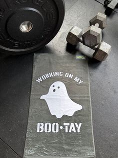 a towel that says working on my boo - tay next to a barbell weight