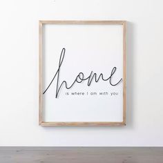 a wooden frame with the words home is where i am with you written in cursive font