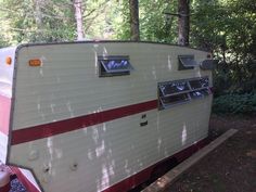 an old trailer is parked in the woods