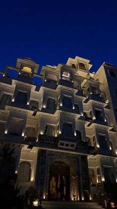 the building has many balconies and lights on it's sides at night