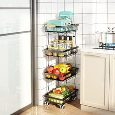 three tiered fruit and vegetable rack in a kitchen with white tile wall behind it