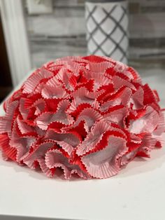 a red flower sitting on top of a white table