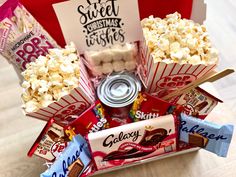 the popcorn bucket is filled with sweet treats and candy bar wrappers, including marshmallows