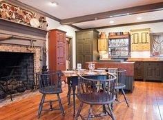 a dining room table with chairs around it in front of a fire place and oven