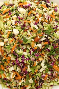 a salad with carrots, celery, onions and lettuce in a white bowl