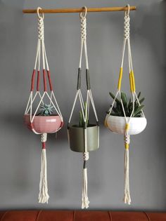 three hanging planters with plants in them