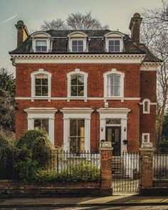 a large red brick house with white windows