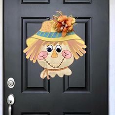 the front door is decorated with an image of a scarecrow wearing a hat and holding a pumpkin