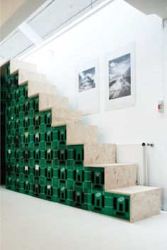 there is a staircase made out of green blocks in the room with pictures on the wall