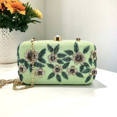 "Beautiful Embroidery Handmade clutch bag. It is stylish Embroidery with flowers makes it perfect for party and everyday wear. It comes with a metal sling chain. Features: - Fabric lining on the inside to keep your belongings safe - Metal magnetic lock closure - Detachable sling chain This clutch can be worn as a crossbody bag or a shoulder bag with the sling chain or can simply be carried in hand. It is spacious enough to carry mobile phones, lipsticks, Keys and other small accessories. Dimensi Rectangular Embroidered Clutch For Events, Formal Clutch With Floral Embroidery, Rectangular Floral Embroidery Pouch, Embroidered Evening Clutch Pouch, Floral Embroidered Clutch For Party, Floral Embroidery Clutch For Party, Party Clutch With Floral Embroidery, Embroidered Rectangular Clutch For Evening, Embroidered Evening Clutch Bag