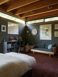 a bedroom with green walls and wooden ceiling