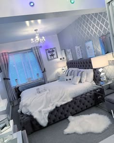 a bedroom with a bed, chair and chandelier in the middle of it