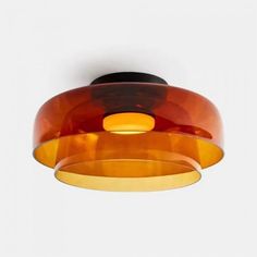 an orange and black light fixture on a white wall