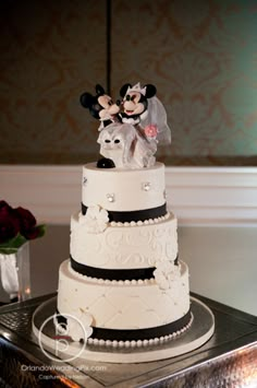 a wedding cake with mickey and minnie on top