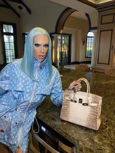 a mannequin holding a white purse in a room with marble counter tops and walls