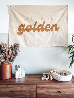 there is a sign that says you're so golden on the wall above a dresser