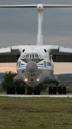 an airplane is sitting on the runway at dusk