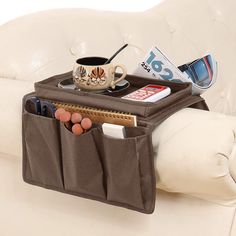 a white couch with a coffee cup and magazine holder on it's back pocket