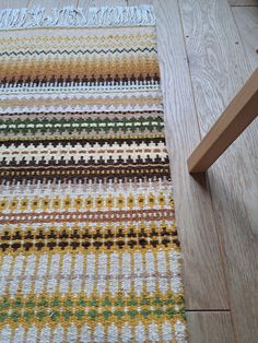 a multicolored rug on the floor next to a wooden bench