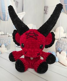 a red and black stuffed animal sitting on top of a table