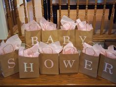 baby shower gift bags sitting on top of a wooden table next to a stair case