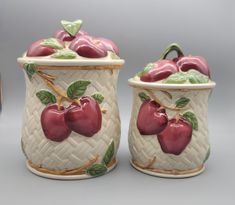 two ceramic canisters with apples painted on them