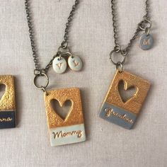 three necklaces with different designs on them and one has a heart in the middle