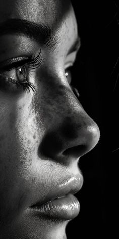 a black and white photo of a woman's face with freckled eyelashes