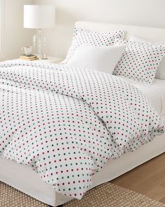 a bed with polka dot sheets and pillows