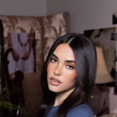 a woman with long dark hair is posing for the camera