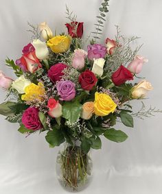 a vase filled with lots of different colored roses