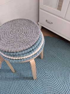 three round rugs stacked on top of each other in front of a white dresser