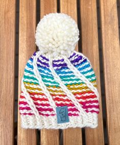 a multicolored hat sitting on top of a wooden bench