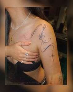 a woman with a tattoo on her arm and chest is looking down at the camera