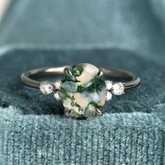 a green and white ring sitting on top of a blue blanket