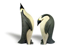 two penguins are standing next to each other